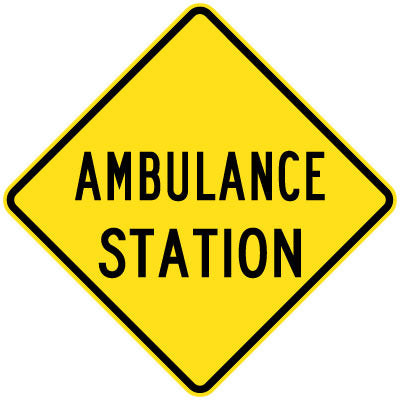 The W5-37 - Ambulance Station sign is a yellow, diamond-shaped sign displaying "AMBULANCE STATION" in bold, black, all-capital letters.