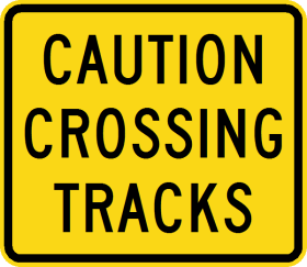 The W8-251n - Caution Crossing Tracks sign is a yellow rectangle with black text that reads "CAUTION CROSSING TRACKS," warning of an upcoming railroad or tramway crossing.