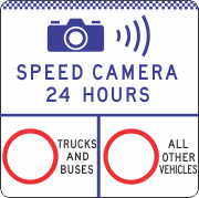 A sign with a camera icon, sound waves, "SPEED CAMERA 24 HOURS," and two circles labeled "TRUCKS AND BUSES" and "ALL OTHER VEHICLES." Product: G6-327-3n – Speed Camera 24 Hours / Variable Speed Limit Enforced.