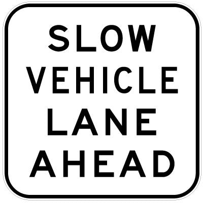 The G9-10 - Slow Vehicle Lane Ahead sign is a square sign with a white background, black border, and bold uppercase black lettering stating "SLOW VEHICLE LANE AHEAD.