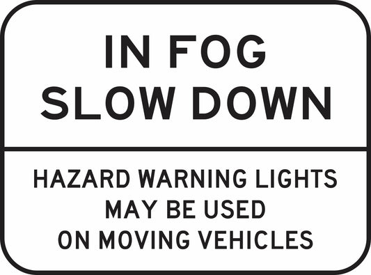The G9-256n road sign displays "IN FOG SLOW DOWN. HAZARD WARNING LIGHTS MAY BE USED ON MOVING VEHICLES" in bold, uppercase black letters on a white background.