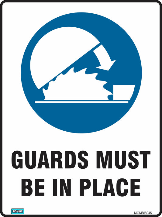 Mandatory Guards Must Be In Place sign features a circular saw blade partly covered by a guard, with an arrow pointing at the guard. Text below reads, "GUARDS MUST BE IN PLACE." This sign helps promote workplace safety.