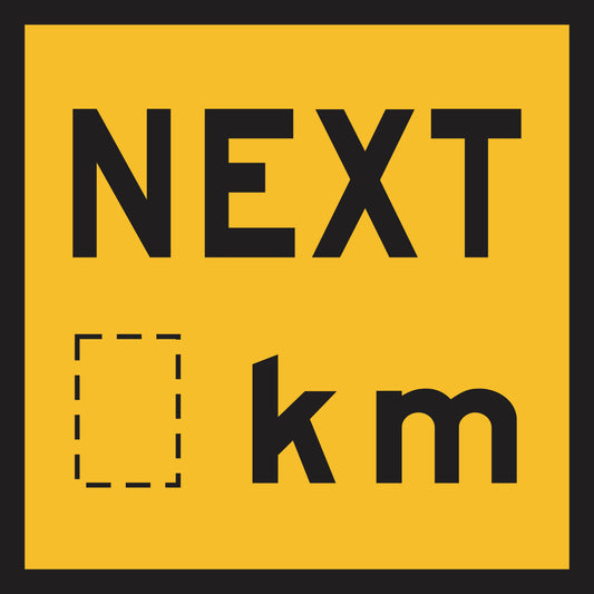 The Next _km (MMS Insert) is a yellow road sign with a black border, displaying "NEXT" above a dashed square and "km," allowing interchangeable messages for adaptable traffic guidance.