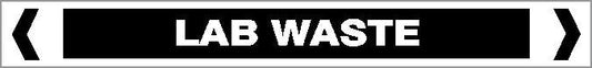 A rectangular "Pipe Marker - OTHER LIQUID - LAB WASTE" sign features a black background, white "LAB WASTE" text, and thick white borders with inward-pointing chevrons on both sides.