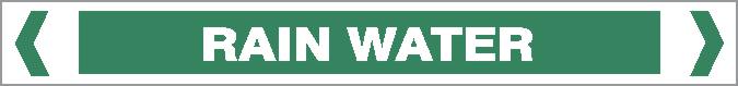 A green rectangular Pipe Marker – WATER – RAIN WATER sign displays "RAIN WATER" in bold white capitals, with white chevron symbols on both sides.
