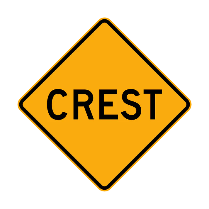 The W5-11 - Crest is a yellow diamond-shaped road sign featuring the word "CREST" in bold black letters, warning drivers of a hillcrest or the top of a hill ahead.