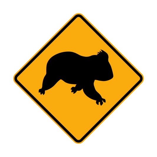A yellow diamond-shaped road sign with a black silhouette of a koala in the center, indicating a W5-47 - Koala (Symbolic) crossing area.