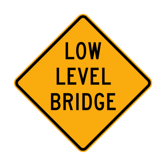 A W5-8 "Low Level Bridge" sign features a yellow diamond shape with "LOW LEVEL BRIDGE" in black capital letters centered on the face.