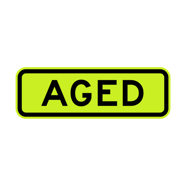 The W8-18 - Aged sign is rectangular, yellow-green with a black border, and features the word "AGED" in bold black capital letters at the center.