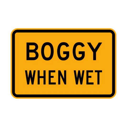 The W8-21 - Boggy When Wet sign is a rectangular yellow road sign with a black border and the words "BOGGY WHEN WET" in bold, black capital letters.